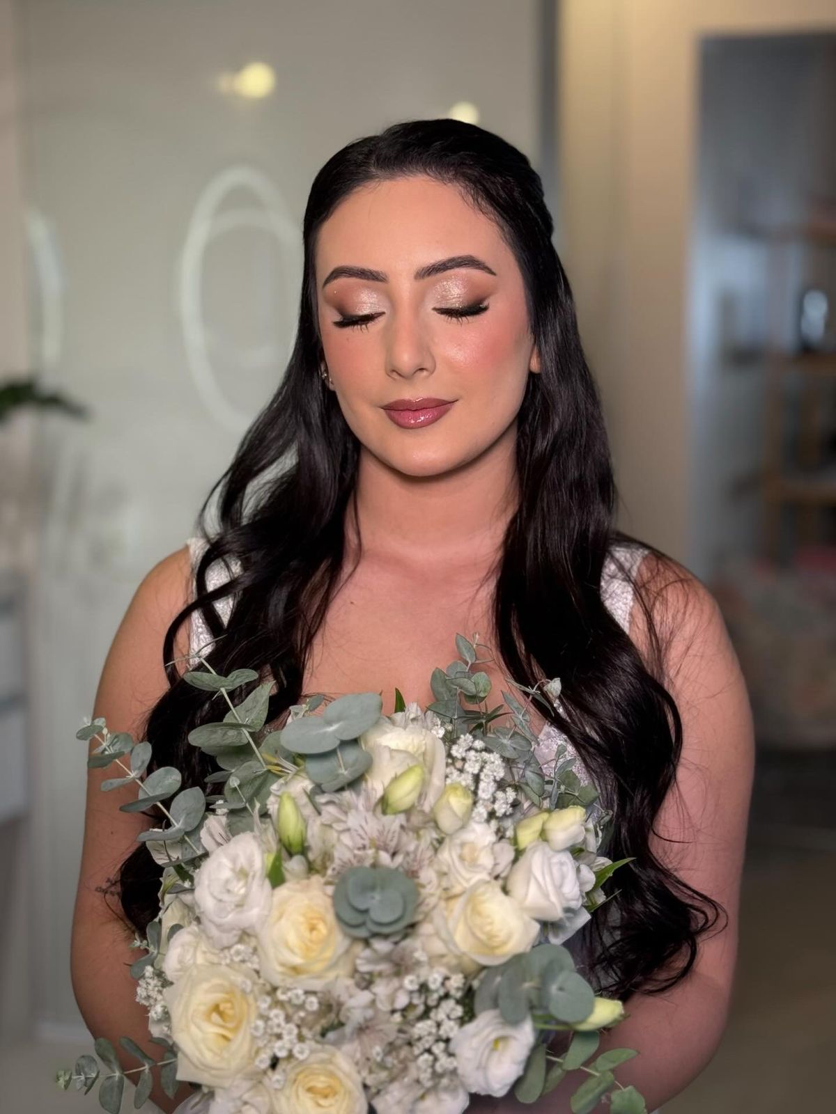 Noiva morena com buquê, olhos fechados